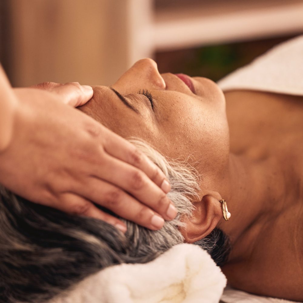 Woman, facial and head massage at spa for beauty, skincare treatment and healing at cosmetics salon.